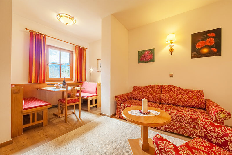 Living room and dining table - holiday flat B - Hotel Hubertushof