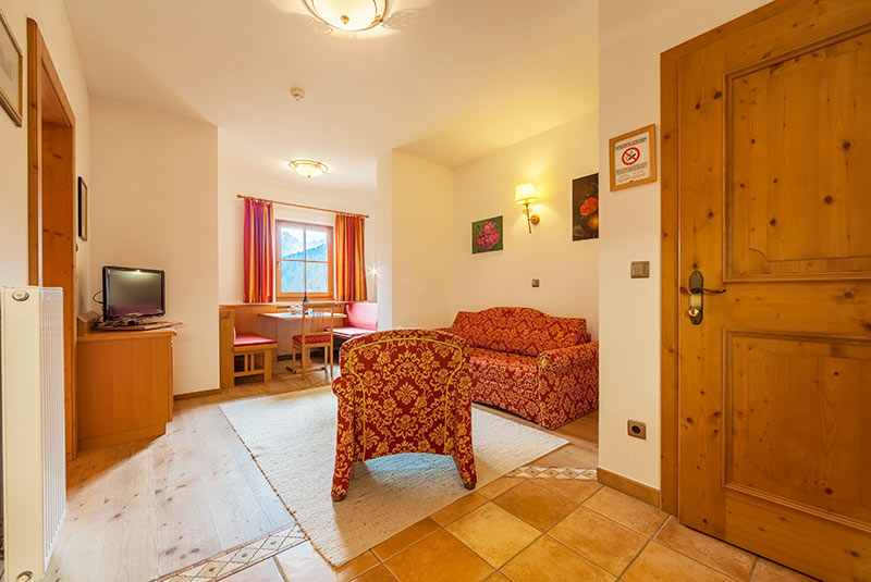 Living room with TV and table - Suite - Hotel Hubertushof